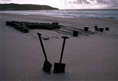 Palas y cubos utilizados para la limpieza de chapapote en la playa de Amela, en Fisterra (A Coruña).