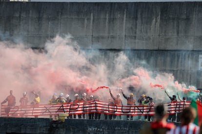 Operarios encienden bengalas en una orilla del Nervión. 