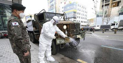 Soldados coreanos aplican desinfectante en las calles de Daegu.