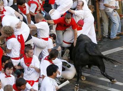 Uno de los toros de Domecq carga contra los mozos en el tramo del Ayuntamiento.