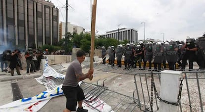 Un manifestante intena agredir a la policía