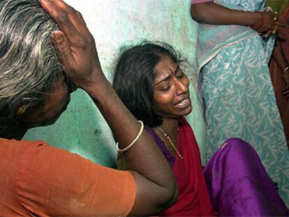 Dos familiares de los niños muertos en el incendio de una escuela de India lloran en el hospital de Kumbakonam.