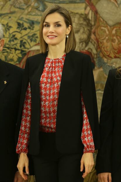 El negro combina con todo y doña Letizia hizo gala de ello en enero de 2016, durante una recepción con la Fundación Secretariado Gitano. Con la misma capa de Zara y pantalones y tacones negros, la reina destacó en su conjunto una blusa roja con estampado de pata de gallo.