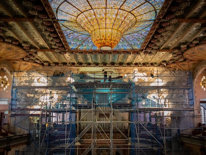 Un operario trabaja en el Palau de la Música durante la restauración del conjunto escultórico del escenario.