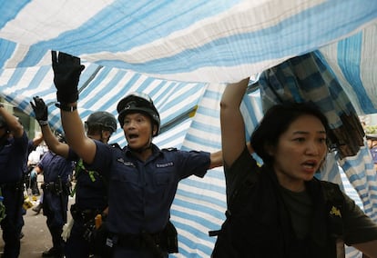 Agentes de policía retiran una lona del distrito urbano de Mong Kok en Hong Kong.