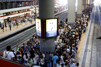 Una multitud espera la llegada de los trenes de cercanías en la estación de Atocha.