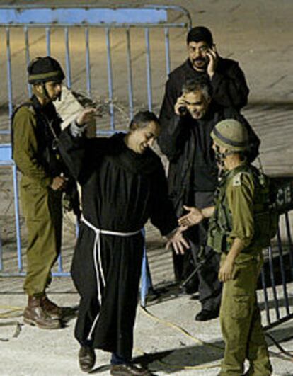 Un cura se dispone a chocar su mano con la de un soldado israelí en Belén.