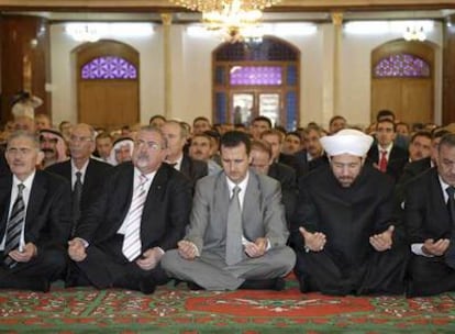 El presidente sirio, Bachar el Asad (centro), reza en la mezquita de Khaled bin al-Walid, en la ciudad siria de Homs.