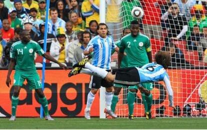 Heinze remata de cabeza tras un córner el gol de Argentina ante la mirada de su compañero Tévez y de los nigerianos Kaita y Yobo.