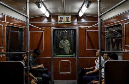 Retratos de los últimos líderes norcoreanos Kim Il Sung y Kim Jong Il en un tren en la estación de metro de Pyongyang.