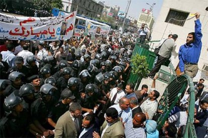 La policía egipcia se interpone entre los manifestantes pro Mubarak (izquierda) y los opositores ayer en El Cairo.