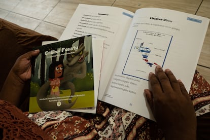 Soraida Aimé Enríquez Bermúdez, de 39 años, muestra un libro de gramática garífuna para niños en Livingston, Guatemala el 12 de diciembre de 2024.