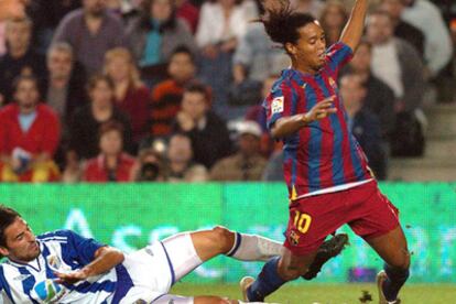 Juan Rodríguez despeja la pelota ante Ronaldinho en la jugada que originó el penalti a favor del Barça.