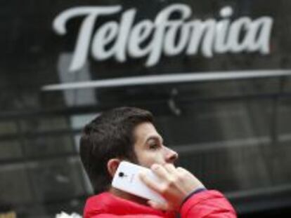 Un chico habla por un m&oacute;vil frente a la tienda de Telef&oacute;nica en el centro de Madrid.