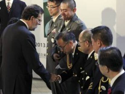 El presidente del Gobierno español, Mariano Rajoy (i), saluda a varios de los "héroes de Fukushima", el colectivo de integrantes de las fuerzas de seguridad y trabajadores de la central nuclear que arriesgaron su vida para intentar controlar las consecuencias de las fugas en esa instalación, durante la inauguración de la exposición del artista español José María Sicilia titulada "Flores de Invierno", en el Museo de Bellas Artes de la localidad nipona.
