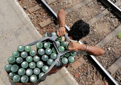 Un vendedor indio transporta refrescos en una estación de tren un caluroso día en Calcuta, en el este de la India.