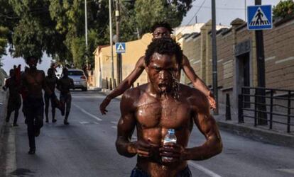 Un hombre se echa agua encima tras haber saltado la Valla de Ceuta.