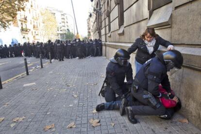 Dos <i>mossos</i> inmovilizan a uno de los funcionarios de prisiones concentrados ante la cárcel Modelo de Barcelona.