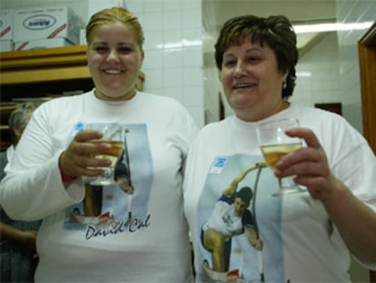 La hermana y la madre de Cal, Paula Cal y María José Figuerosa, brindan por las medallas de David en la panadería que regentan en Cangas de Morrazo.