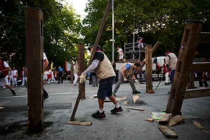 Varios operarios trabajan en el desmontaje del vallado que marca el final de las fiestas de San Fermín.