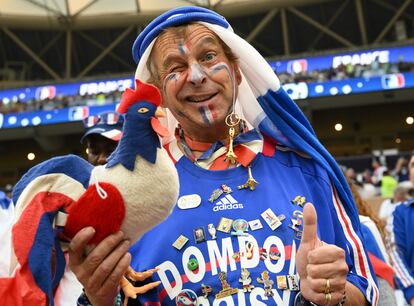 Un seguidor de Francia sostiene un gallo de peluche con los colores de la bandera nacional mientras anima en las gradas.