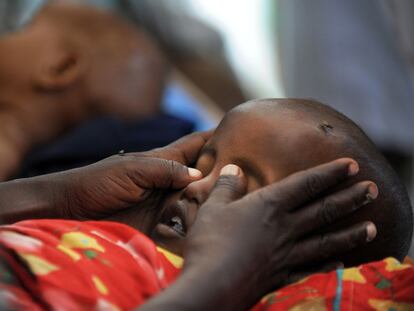 Una madre cierra los ojos a su hijo, que acaba de morir, en Mogadiscio.