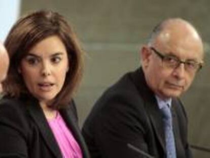 La vicepresidenta del Gobierno, Soraya Sáenz de Santamaría, acompañada de los titulares de Economía, Luis de Guindos (i) y Hacienda, Cristóbal Montoro, durante la rueda de prensa posterior a la reunión del Consejo de Ministros. EFE/Archivo