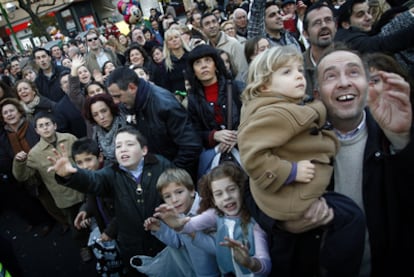 Miles de niños miran ansiosos a  los Reyes Magos en una calle de Sevilla