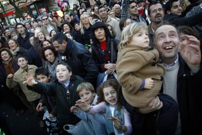 Miles de niños miran ansiosos a los Reyes Magos en una calle de Sevilla