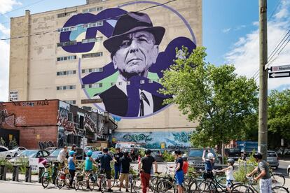 Ciclistas urbanos ante un retrato de Leonard Cohen en una medianera de Montreal, ciudad natal del cantante canadiense.