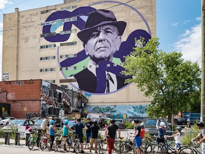 Ciclistas urbanos ante un retrato de Leonard Cohen en una medianera de Montreal, ciudad natal del cantante canadiense.