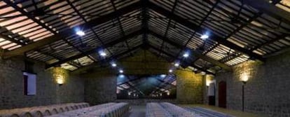 La nave de 1909 de la bodega Cvne, en La Rioja, con las cerchas metálicas que sujetan el techo ideadas en el taller de Eiffel. Al fondo, la fotografía de José Manuel Ballester.