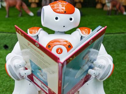 Un robot posa leyendo Pinocho en Westfield, Londres.