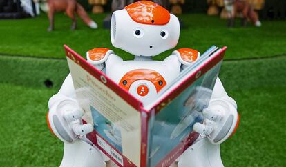 Un robot posa leyendo Pinocho en Westfield, Londres.