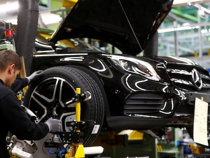 Un empleado del fabricante alemán de automóviles Mercedes Benz ajusta una rueda en la cadena de montaje de la factoría de Rastatt, en febrero de 2019.