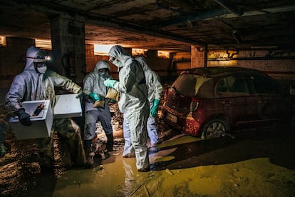 Técnicos del Redit (Institutos Tecnológicos de la Comunitat Valenciana) recogen muestras de lodo de un garaje de Paiporta para analizar los posibles riesgos sanitarios en los bajos de las viviendas afectadas, el 20 de noviembre.Los trajes de protección recuerdan a la peor época de la pandemia del COVID. 