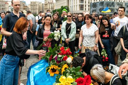 Una mujer depositaba flores este sábado en Kiev sobre el ataúd del joven activista ucranio Roman Ratushni, fallecido en un ataque ruso en el este del país el pasado 9 de junio.