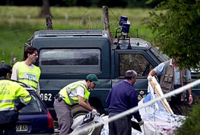 Agentes de la Guardia Civil recogen los restos de la pancarta a la que los etarras adosaron la bomba. PLANO GENERAL