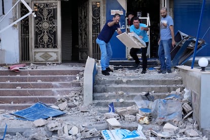 Libaneses retiran los escombros de la entrada de una tienda tras un un ataque aéreo israelí en el centro de Beirut, este lunes. 