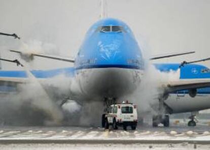 Trabajadores deshielan un avión de la aerolínea KLM en el aeropuerto de Schiphol (Ámsterdam) ayer, lunes.