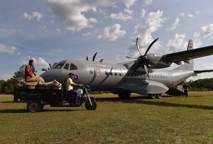 Campesinos transportan sacos de granos de cacao a un avión de la Fuerza Aérea Colombiana en Güerima.