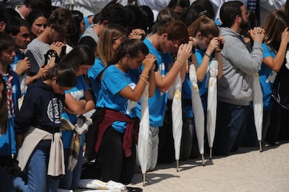 Uno fieles cristianos rezan de rodillas durante la misa, el 13 de mayo.