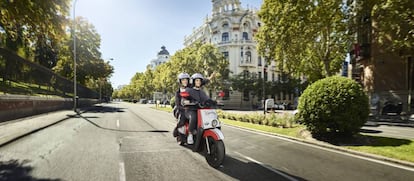Una pareja circula en una moto eléctrica de Acciona.