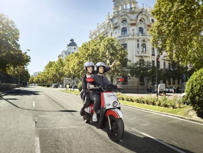 Una pareja circula en una moto eléctrica de Acciona.