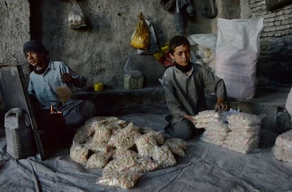 Dos niños afganos trabajan en una fábrica tradicional de caramelos, hoy en Ghazni (Afganistán) durante el Día Mundial contra el Trabajo Infantil.  