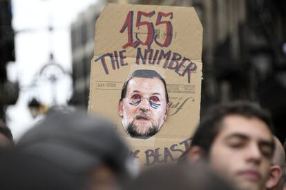 Un manifestante sostiene una pancarta con una imagen que representa al presidente Mariano Rajoy durante la manifestación frente al Palacio de la Generalitat, en Barcelona.