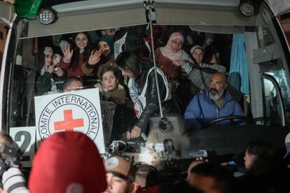 Prisioneras palestinas saludan desde el interior de un autobús a su llegada a la ciudad de Beitunia, este lunes.