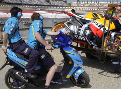 Técnicos de Suzuki fisgonean la moto de Hayden tras un accidente del estadounidense en Montmeló.