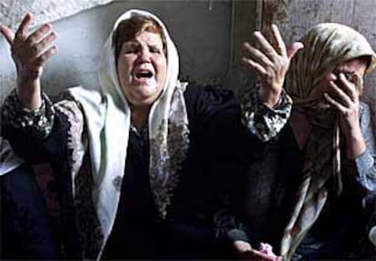 Dos mujeres palestinas lloran durante el funeral de Yeheh al Day, muertos por disparos israelíes en Gaza.