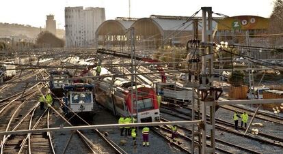 T&eacute;cnicos de Renfe ante el tren descarrilado en la estaci&oacute;n de Francia. 